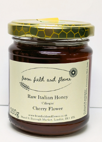 jar of cherry flower honey on a white background